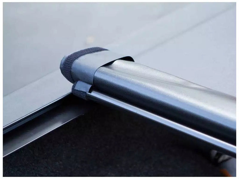 Close-up of the Access Lorado roll-up tonneau cover: close-up of a rolled vinyl cover held by a hook-and-loop storage strap over the bed rail