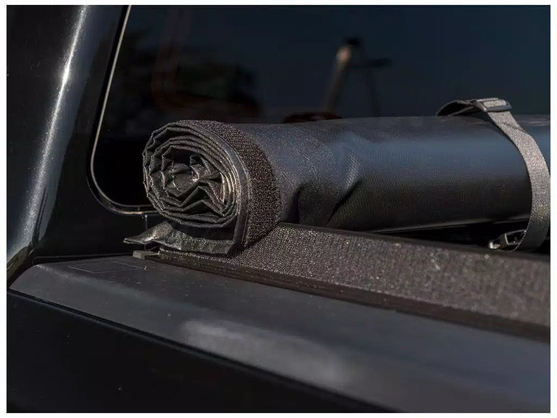 Close-up of the Access Original roll-up tonneau cover: close-up of a rolled vinyl cover held by a storage strap on the hook-and-loop side rail