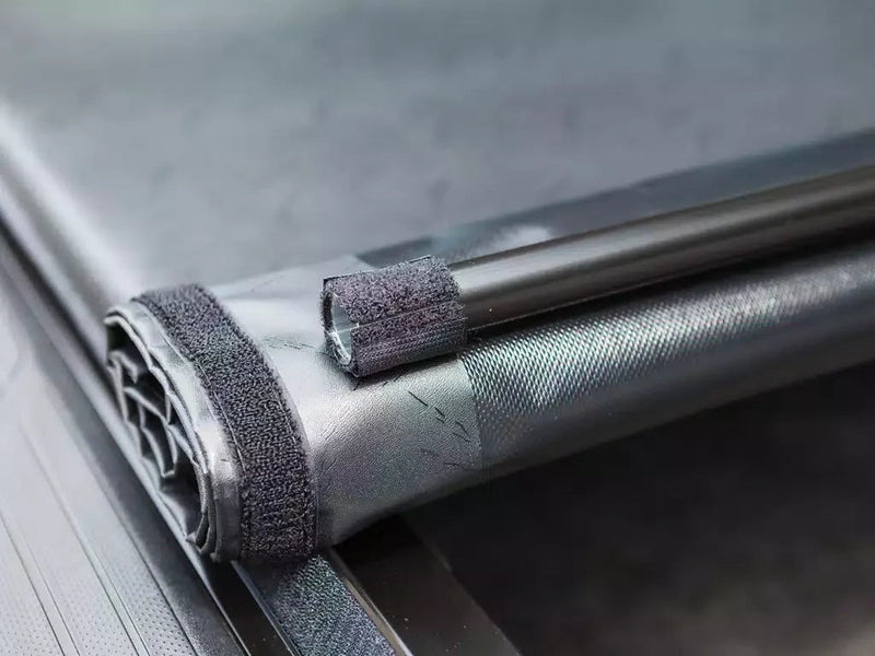 Close-up of the partly rolled cover end with hook-and-loop strips and the front bow