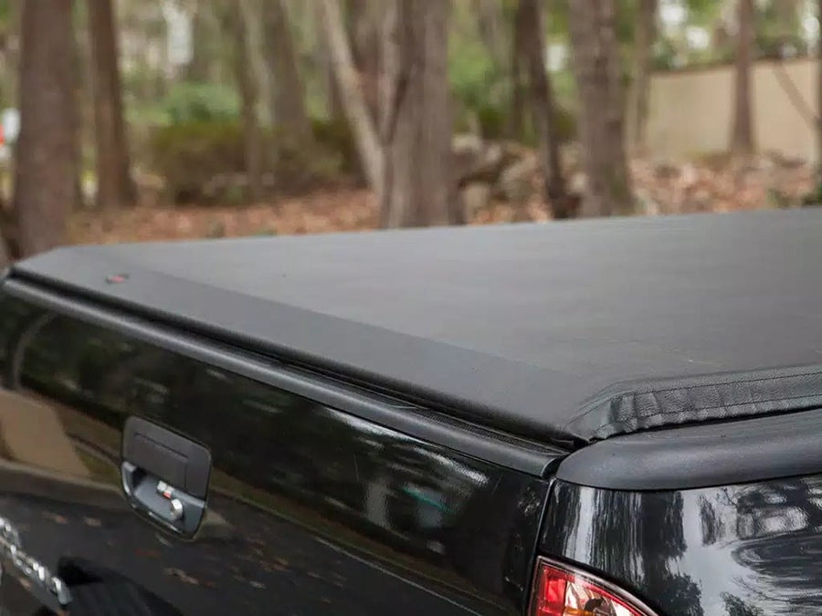 Access roll-up tonneau cover: Close-up of a closed black vinyl roll-up cover's rear corner above a black tailgate
