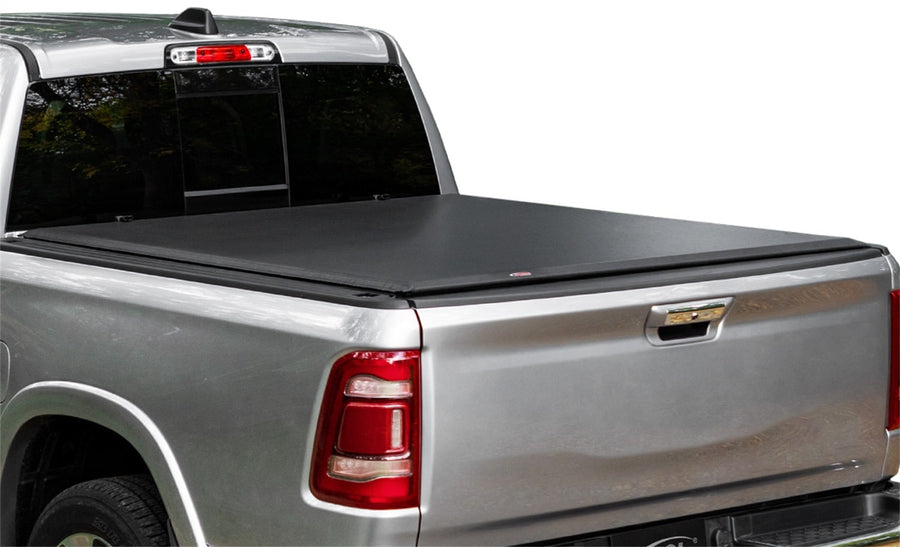 Access Lorado roll-up tonneau cover: Silver pickup with a black vinyl roll-up cover closed flat over the bed, white background