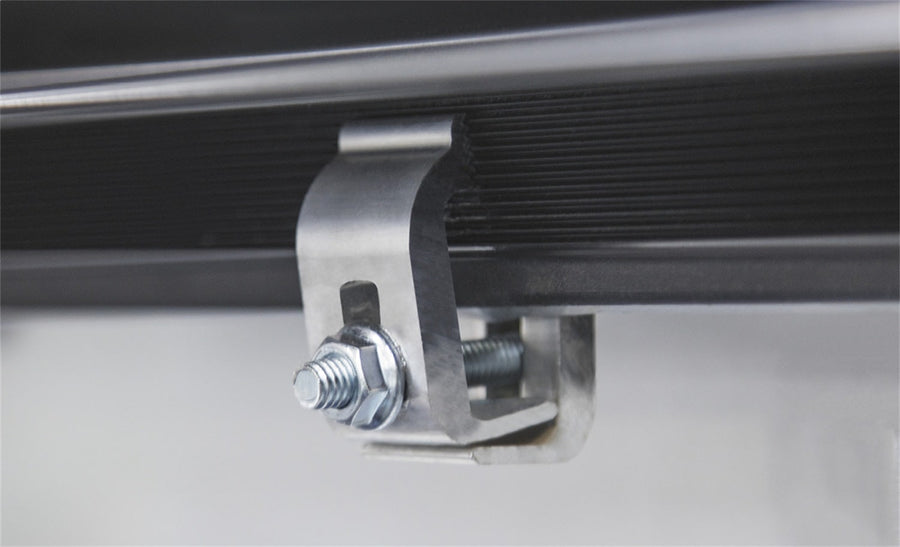 Access Lorado roll-up tonneau cover: Close-up of an aluminum side-rail clamp with bolt and nut on a black rail