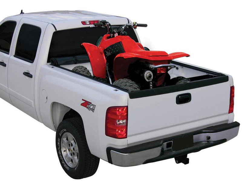 White pickup with the cover rolled to the cab and a red ATV loaded in the open bed