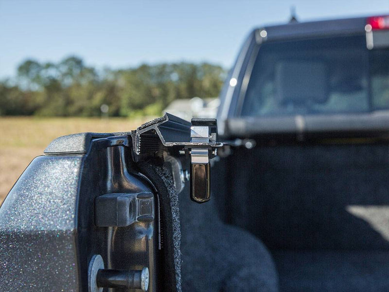 Rear corner latch on the side rail at the tailgate, cover lifted