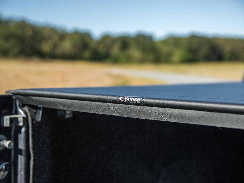 Low close-up along the closed cover's side edge with the Vanish logo on the rail