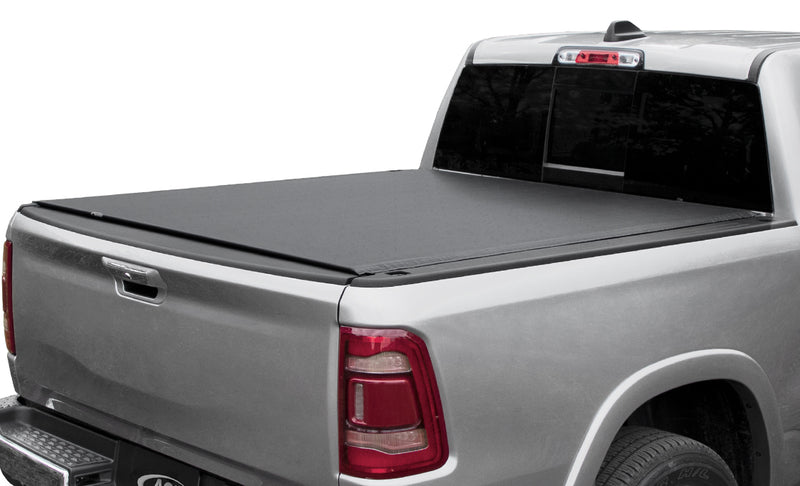 Access Vanish roll-up tonneau cover on a pickup bed: silver pickup on white background, black low-profile roll-up cover closed flat over the bed