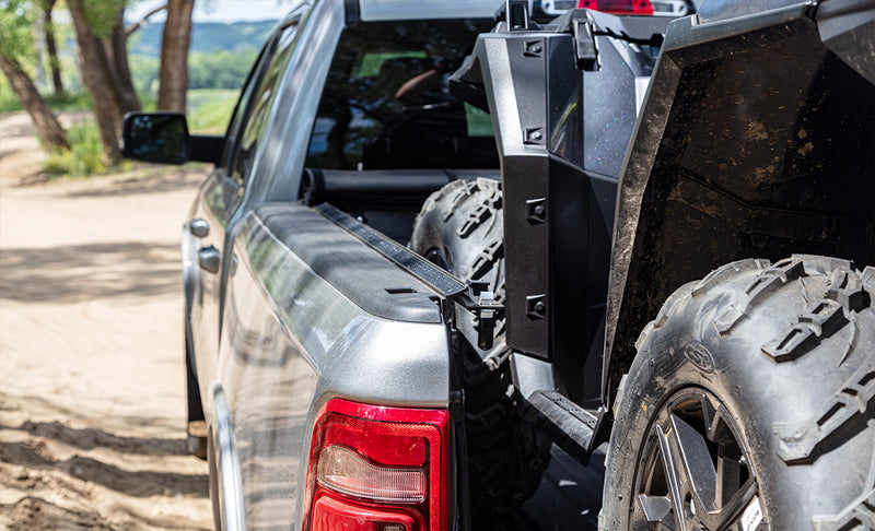 Access Vanish roll-up tonneau cover on a pickup bed: silver pickup with the cover rolled to the cab and an off-road utility vehicle loaded in the bed (off-road utility vehicle cargo shown, not included)