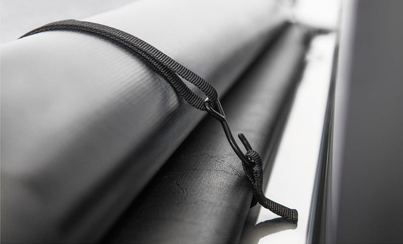 Studio close-up of the elastic storage strap wrapped around the rolled cover