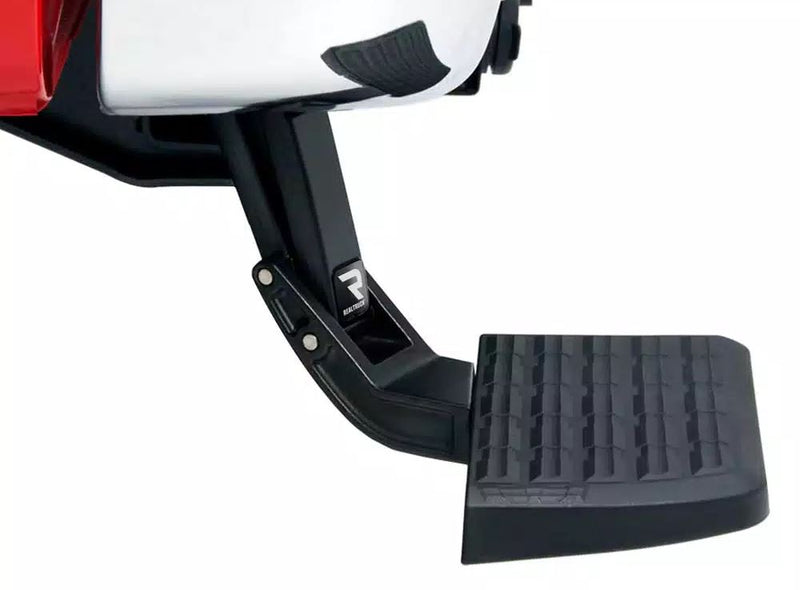 BedStep deployed below a white bumper corner with a red tail lamp, close-up of the step pad