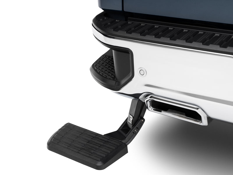 BedStep deployed under a white rear bumper, showing the step pad and swing-arm linkage