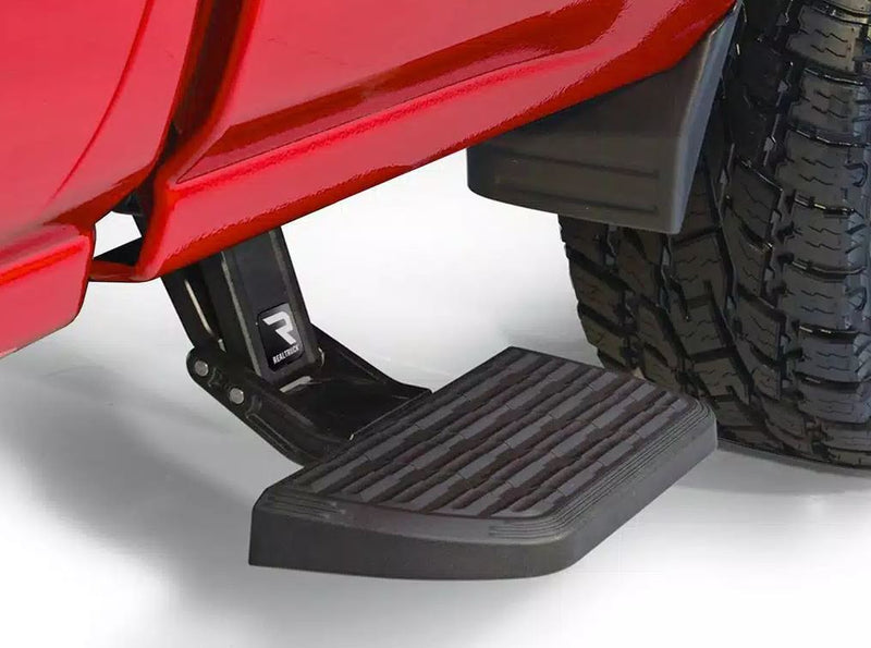 Close-up of the BedStep2 pad deployed ahead of the rear tire of a red pickup