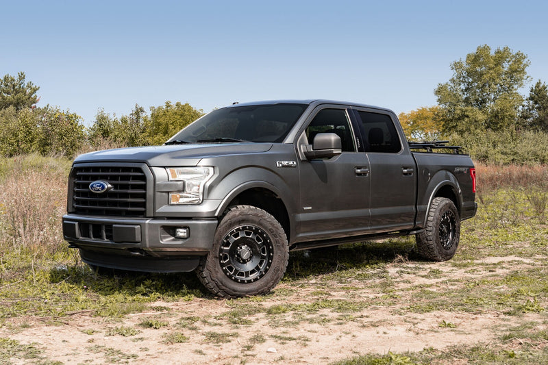 Gray crew-cab pickup parked in a grassy field