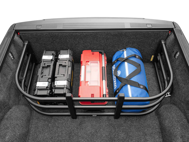 BedXTender HD Max corralling two cases, a red toolbox and a blue duffel against the closed tailgate