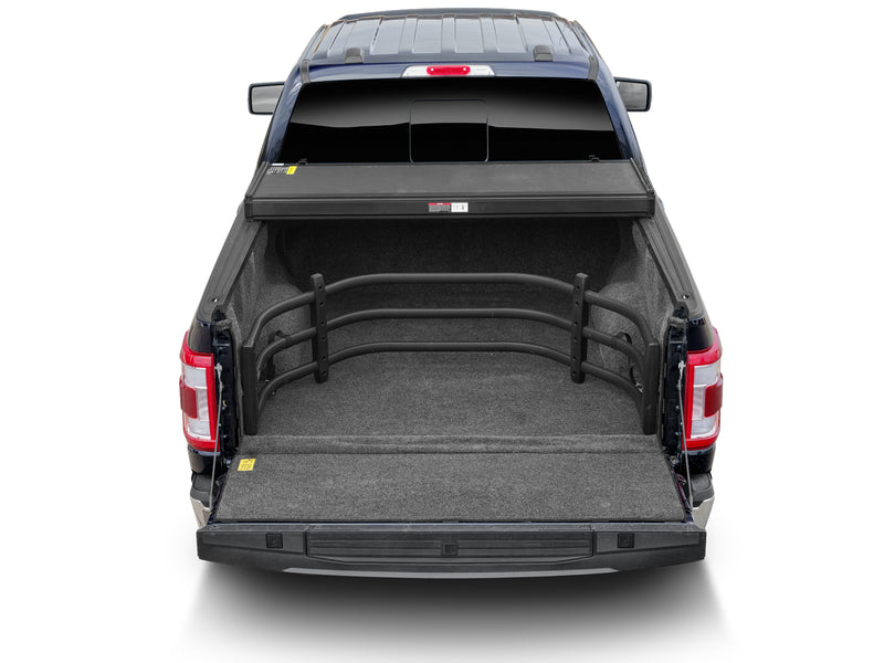 Rear view of a pickup with the tailgate down and the BedXTender HD Sport stowed against the front of the bed