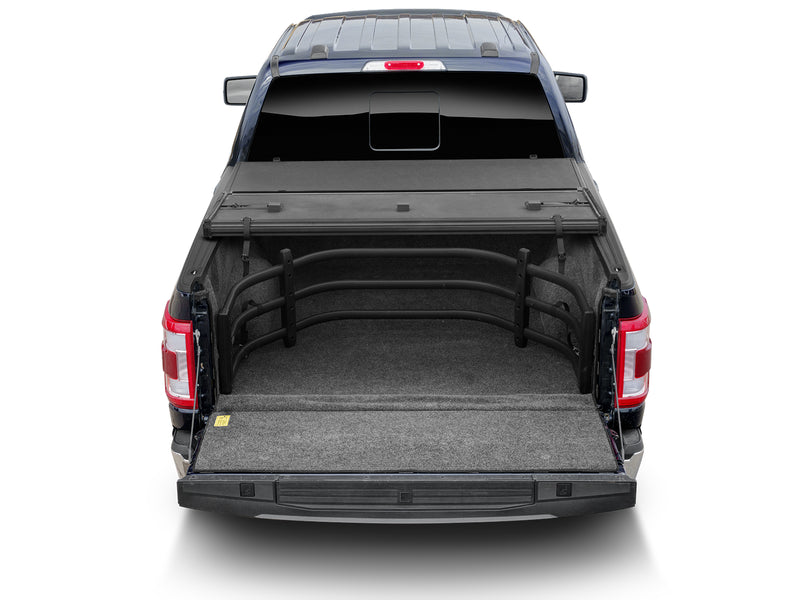 Rear view of a pickup bed with the BedXTender HD Sport stowed forward and the hard cover folded
