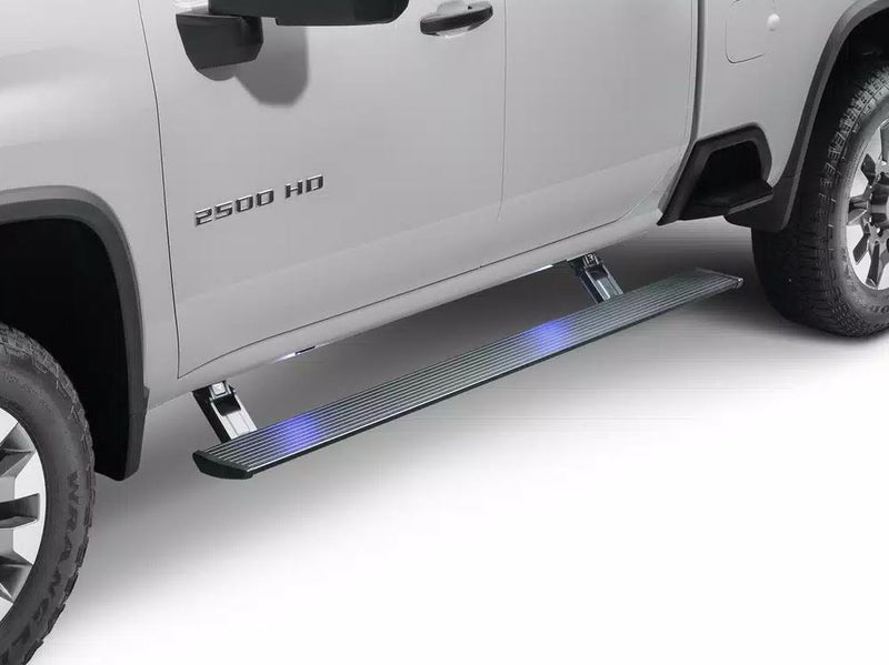Lit PowerStep deployed under the doors of a silver heavy-duty pickup, studio
