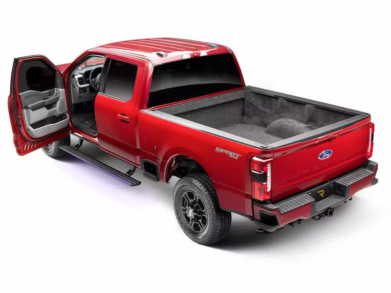 Red heavy-duty pickup with the front door open and the lit running board deployed, studio