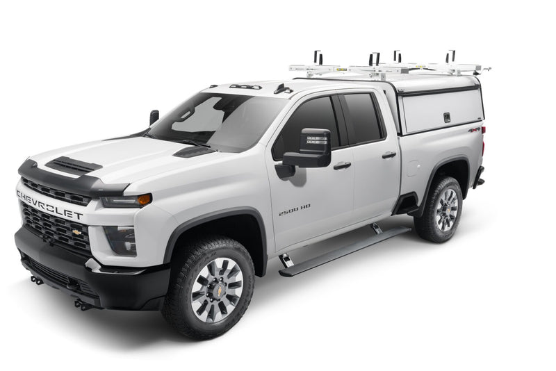 White heavy-duty pickup with a work cap and ladder rack, the running board deployed, studio
