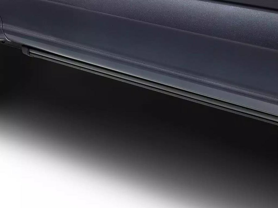 Running board tucked under the rocker of a dark vehicle, studio