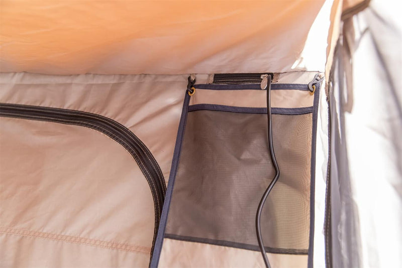 Interior detail of the ARB awning room showing the zip doorway, hanging mesh storage panel and awning underside overhead