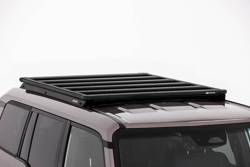 ARB BASE Rack platform fitted low over a wagon roof, studio lit, showing how little the rack stands off the roof line