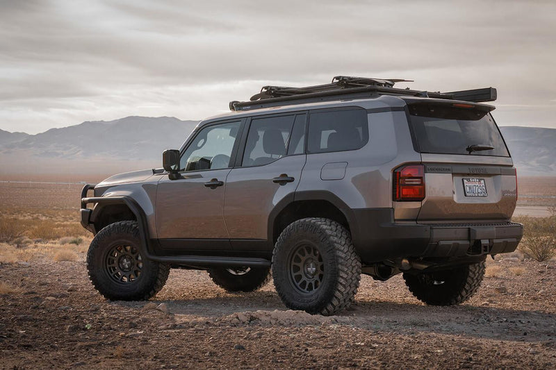 Four wheel drive parked in desert scrub carrying an ARB BASE Rack loaded with an awning and touring gear