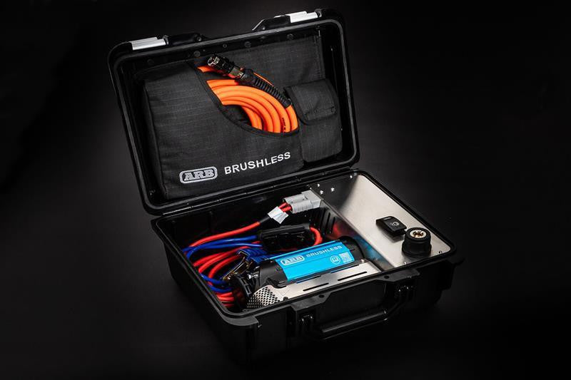 ARB CKBLP12 brushless single motor portable 12V air compressor shown in its open black hard case with one blue anodized BRUSHLESS motor unit, coiled leads and an orange air hose in the ARB BRUSHLESS lid pocket