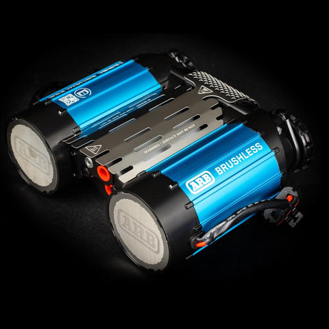 ARB CKBLTA12 brushless twin motor on-board 12V air compressor, two blue anodized barrels marked ARB BRUSHLESS either side of a vented cover plate, with two mesh filter end caps