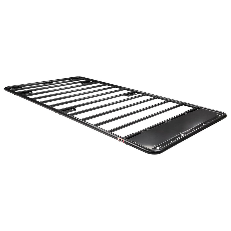 ARB Classic steel flat roof rack on white, a long flat black tube platform with spaced cross bars, no raised perimeter rails, and a wind deflection panel at one end