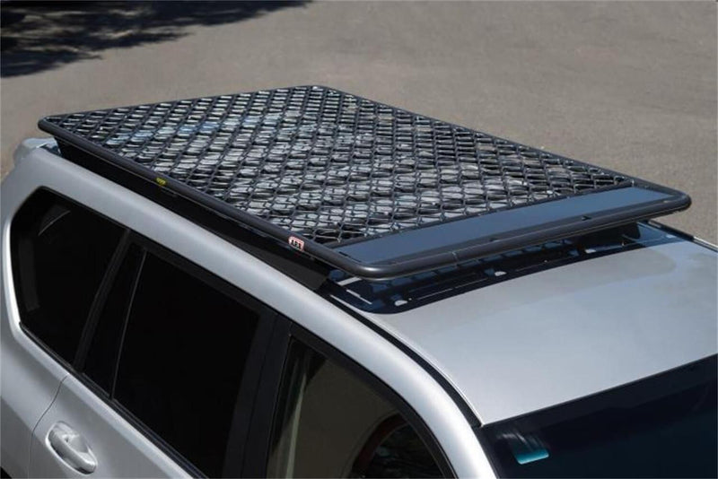 ARB Classic aluminum flat roof rack with a mesh floor fitted to the roof of a silver 4WD, showing the diamond pattern mesh deck and the low-profile perimeter frame