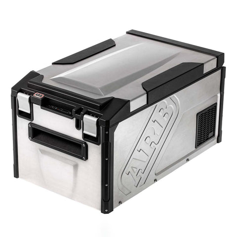 ARB Elements 63 qt weatherproof fridge freezer, three quarter studio view showing the brushed 304 stainless body with embossed ARB logo, black corner armor, latches and weatherproof control panel