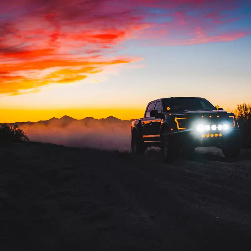 Pickup truck with NACHO lights lit at sunset in the desert