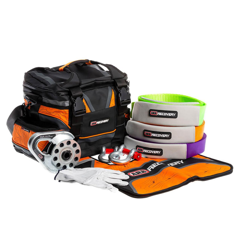 ARB Premium Recovery Kit laid out: large recovery bag with snatch strap, tree trunk protector, winch extension strap, snatch block, shackles and gloves, in use