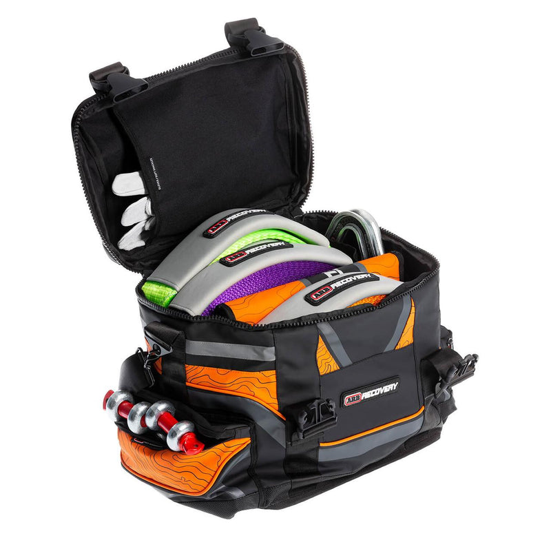 ARB Premium Recovery Kit laid out: large recovery bag with snatch strap, tree trunk protector, winch extension strap, snatch block, shackles and gloves, packaging
