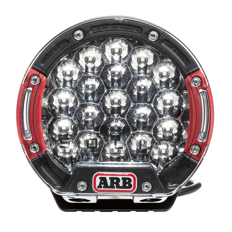 ARB Intensity Solis 21 spot driving light face on, black die-cast body with red side accents and a clear lens over deep round spot reflector cups, ARB badge at the base