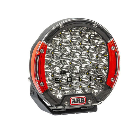 ARB Intensity Solis 36 flood driving light at an angle, larger squat black die-cast body with red side accents and a clear lens over a dense array of faceted flood optics, ARB badge at the base
