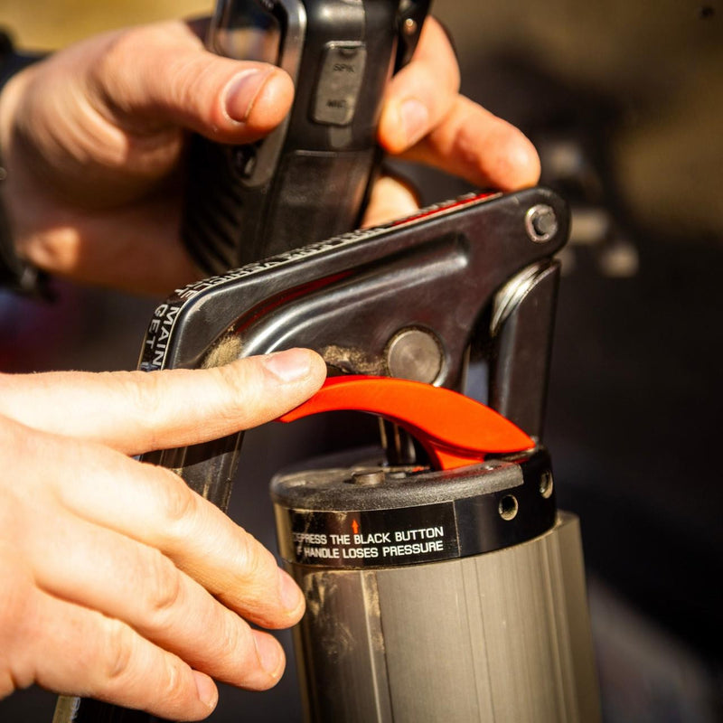 Hand pressing the ARB JACK release lever on the handle