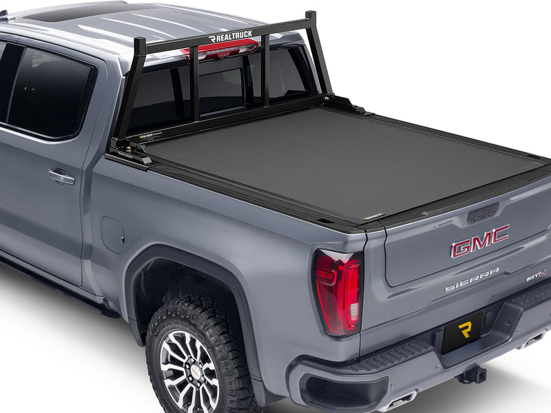 BackRack Open: gray GMC Sierra with a black open headache rack behind the cab and a closed black roll-up tonneau cover