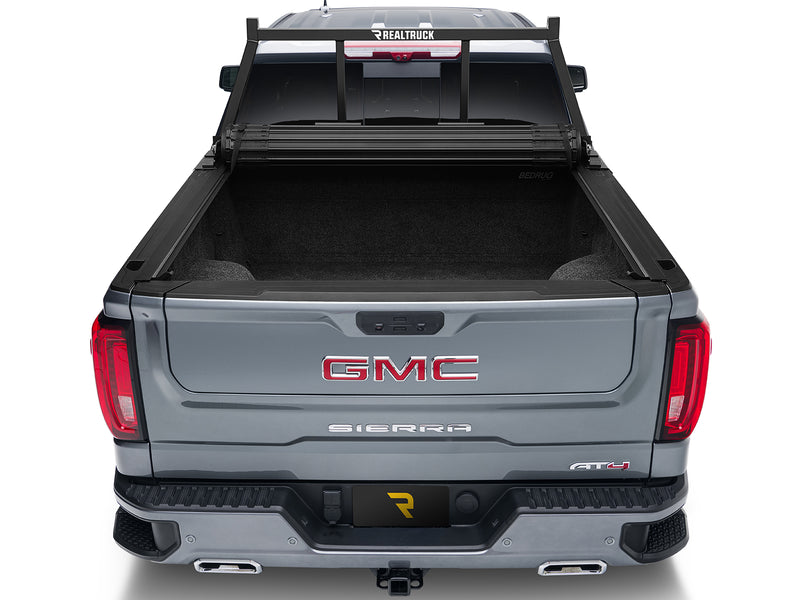 BackRack Open: rear view of a gray GMC Sierra with a black open headache rack and a rolled tonneau cover