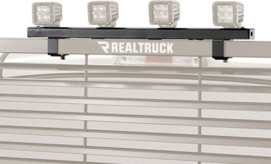 BackRack Utility Light Brackets: Black light bracket bar carrying four cube work lights on the top bar of a rack, with the rack faded to gray.