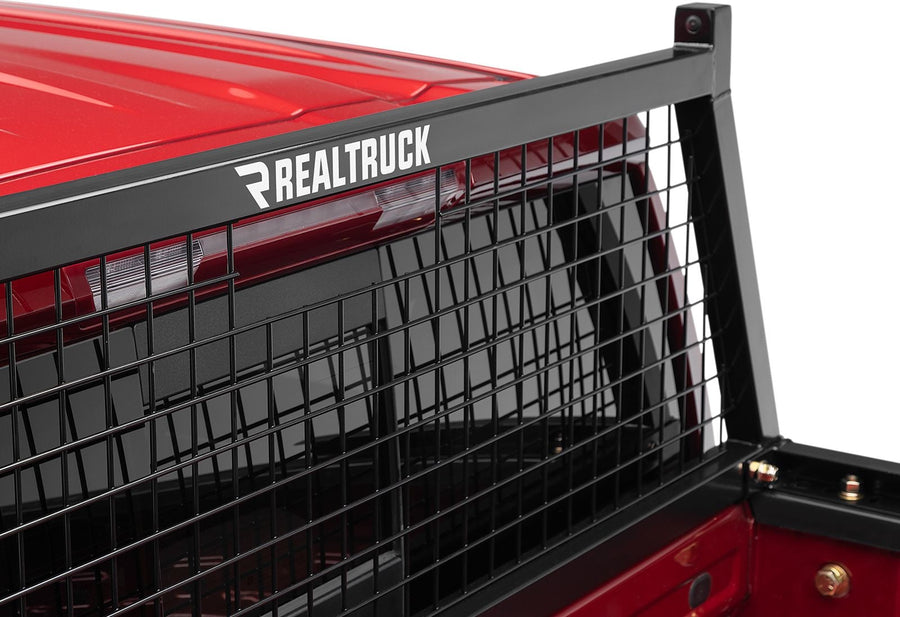 BackRack Safety Headache Rack: Close-up of a black Safety headache rack with RealTruck lettering mounted behind the cab of a red pickup.
