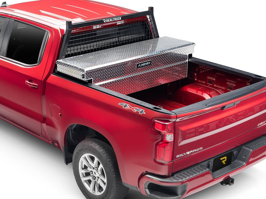 BackRack Safety Headache Rack: Red pickup with a black Safety headache rack behind the cab and a diamond plate crossover toolbox across the bed.