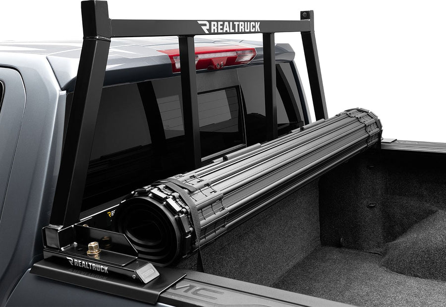 BackRack Open Headache Rack: A black open headache rack stands behind a rolled tonneau cover on a gray GM pickup.