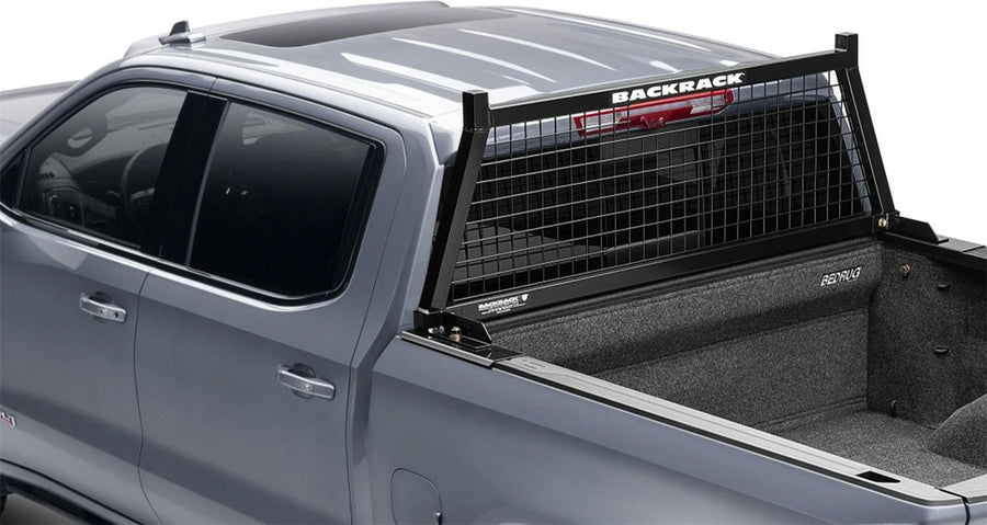 BackRack Utility Body Safety Rack: A black mesh headache rack mounted behind the cab of a silver pickup with a carpeted bed liner.