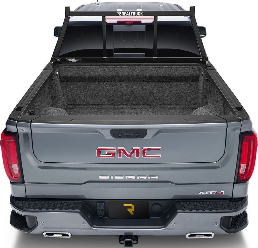 BackRack Open Headache Rack: Rear view of a gray pickup with a black open headache rack mounted behind the cab and an empty carpeted bed.