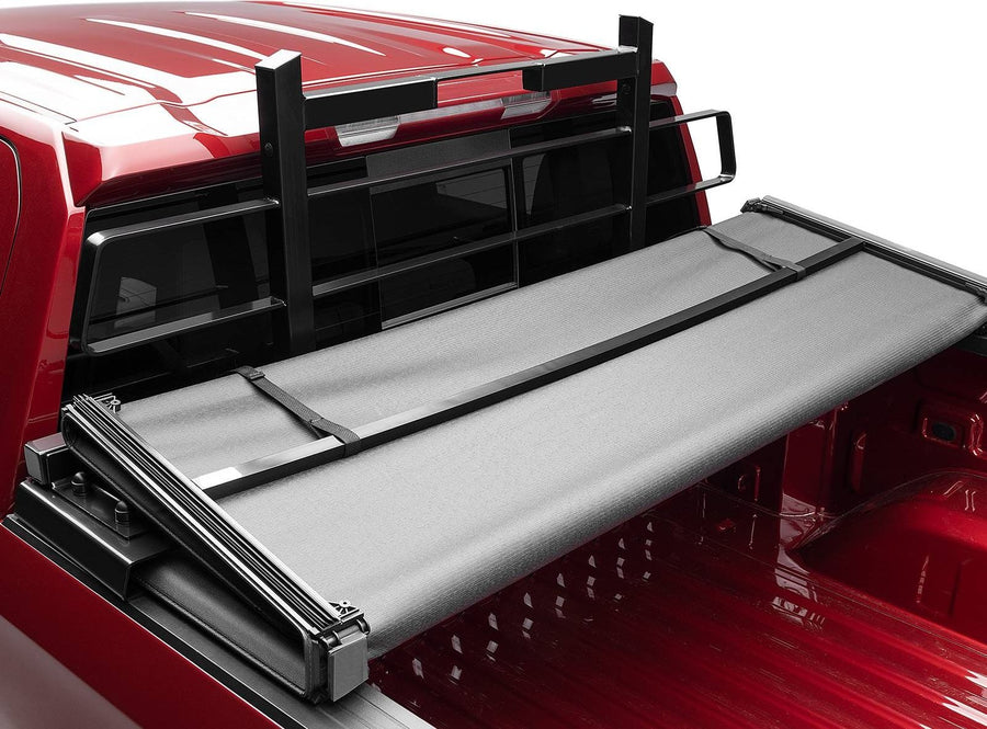 BackRack Original Headache Rack: Black Original headache rack behind a red pickup cab with a folding soft tonneau cover partly open.