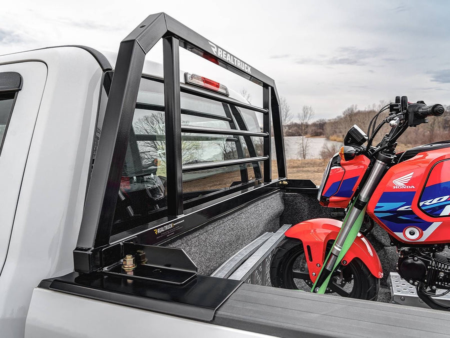 BackRack SR Headache Rack: A black SR headache rack behind the cab of a white pickup with a red minibike strapped in the bed.