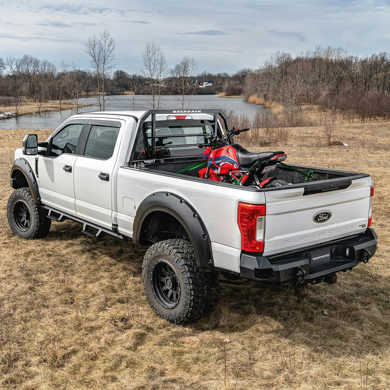 BackRack SR: A white Ford Super Duty with a black SR headache rack carries a red minibike in a field by a lake