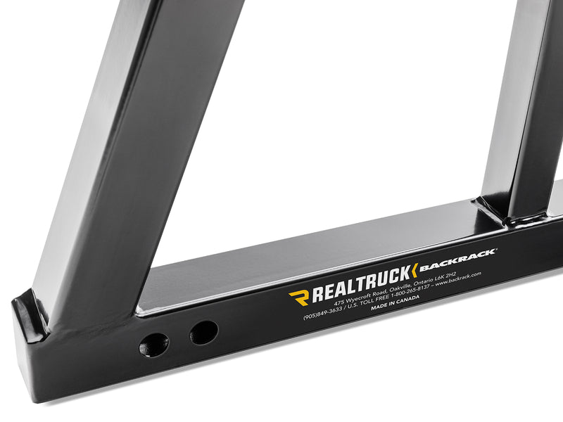 BackRack SRL: close-up of the lower corner of a black headache rack showing the base tube and mounting holes