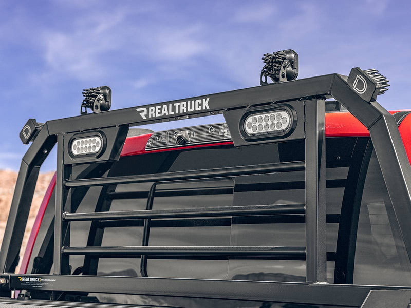 BackRack SRL: low view of a black SRL headache rack with white oval LED lights behind a red truck cab under a blue sky